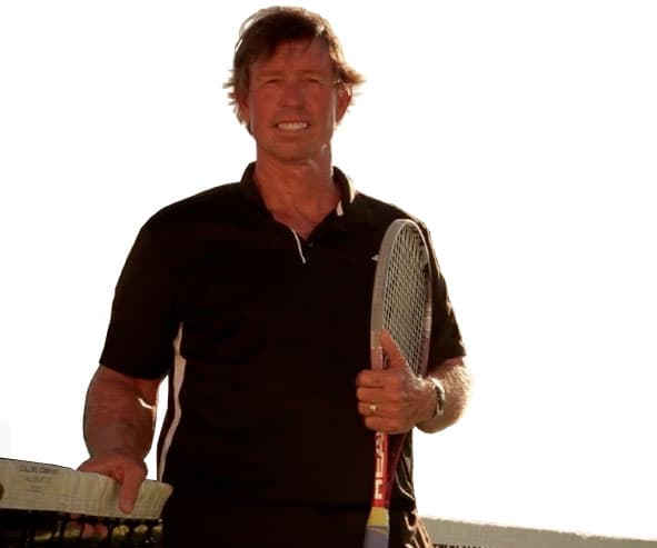 Mike Van Zutphen smiling with racquet at sunset